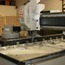 Gantry mill precision machining a beam for a multi head embroidery frame